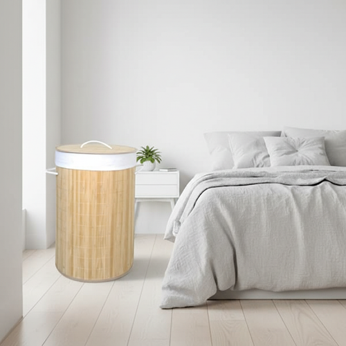 Bamboo round collapsible laundry basket in a bright minimalist bedroom corner
